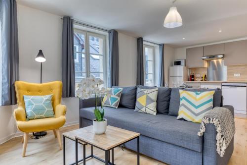 un salon avec un canapé bleu et un fauteuil jaune dans l'établissement Charmants 2 pièces - Hyper centre de Rouen, à Rouen