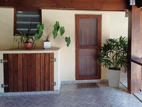 una habitación con puerta y macetas en la pared en Recanto Do Sossego Suítes Hospedagem Domiciliar na Praia, en Boicucanga