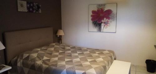 a bedroom with a bed and a picture on the wall at Le Grand Jardin in Aujargues