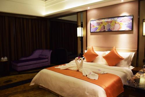 a hotel room with a bed with towels on it at Ramada Foshan Hotel in Foshan