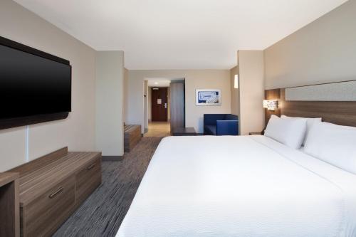 a hotel room with a large bed and a flat screen tv at Holiday Inn Express & Suites I-26 & Us 29 At Westgate Mall by IHG in Spartanburg