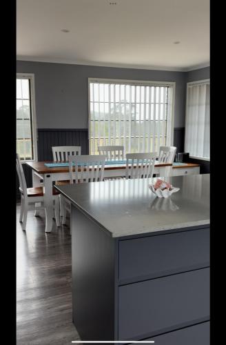 a kitchen with a table and chairs and a dining room at Beach N Berms in Dalmeny