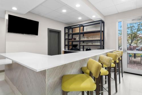 a bar with yellow bar stools and a flat screen tv at Hilton Garden Inn Lexington Georgetown in Georgetown