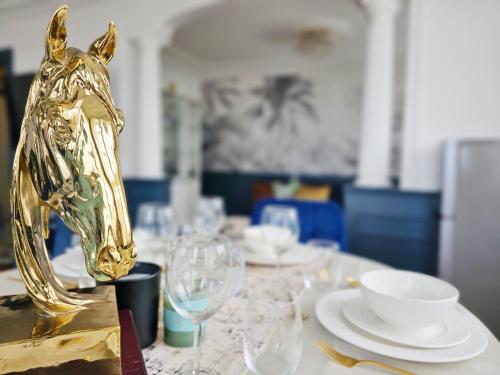 une table avec une statue de cheval en or au-dessus dans l'établissement Apt vue panoramique parking free, à Paris