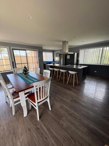 a kitchen and dining room with a table and chairs at Beach N Berms in Dalmeny