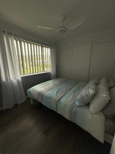 a bedroom with a bed with pillows and a window at Beach N Berms in Dalmeny