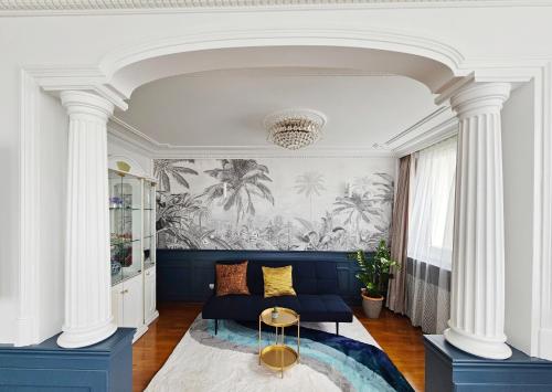 un salon avec un canapé bleu et des colonnes dans l'établissement Apt vue panoramique parking free, à Paris