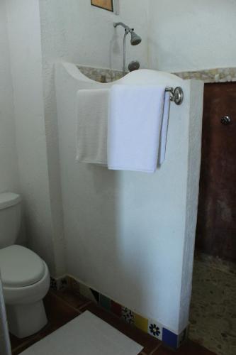 a bathroom with a toilet and a sink with a towel at Wellness Center El Secreto in Tepoztlán