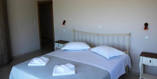 a white bed with two towels on top of it at Villa Maura-Lefkada - Jimdo in Nydri