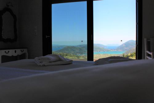 a bedroom with a bed with a large window at Villa Maura-Lefkada - Jimdo in Nydri