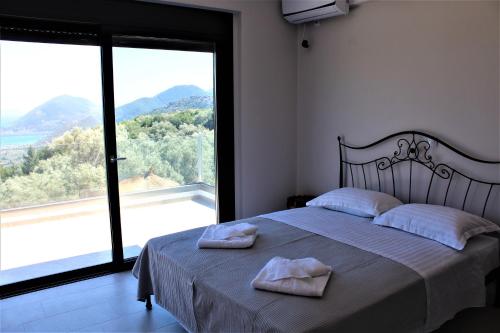a bedroom with a bed and a large window at Villa Maura-Lefkada - Jimdo in Nydri