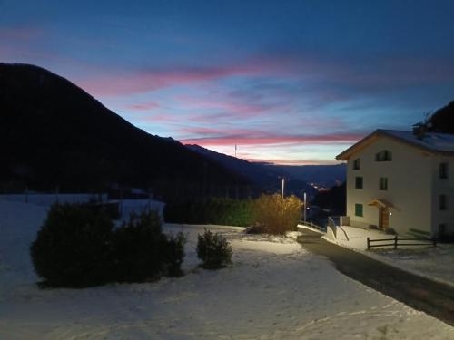 a building with a sunset in the background at Aprica favoloso con terrazzo wi-fi Netlix 4 ospiti comodi 3 minuti dalle piste -davvero comodo in Aprica