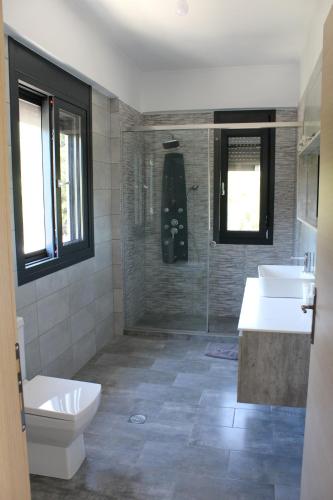 a bathroom with a shower and two sinks and a toilet at Villa Maura-Lefkada - Jimdo in Nydri