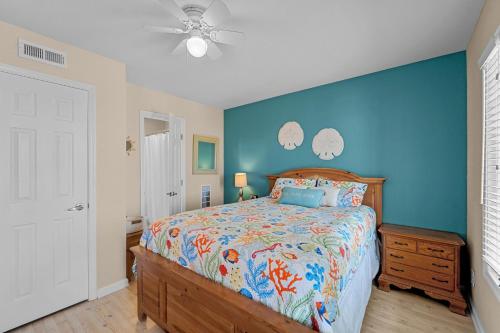 a bedroom with a bed and a blue wall at Finn's Up in Hatteras