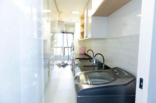 een keuken met een roestvrijstalen wastafel en aanrecht bij Casa Enorme com Piscina, Sauna e Área para Festas in Belo Horizonte