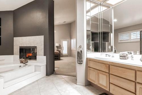 La salle de bains est pourvue d'une baignoire, d'un lavabo et d'une cheminée. dans l'établissement Desert Escape, à La Quinta