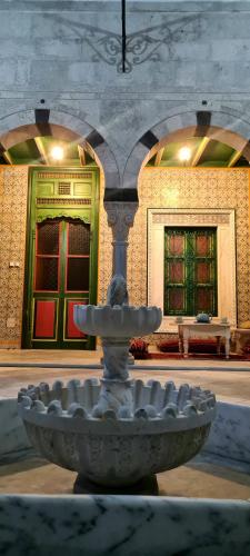 a fountain in front of a building with two windows at Dar Ben Jemia- Sidi Bou Saïd in Sidi Bou Saïd