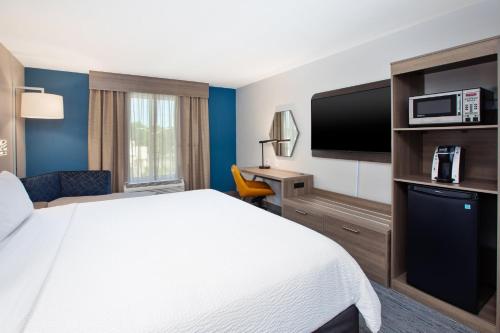 a hotel room with a bed and a flat screen tv at Holiday Inn Express & Suites I-26 & Us 29 At Westgate Mall by IHG in Spartanburg