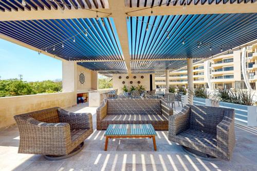 a patio with wicker chairs and tables on a building at Seaside Serenity in Telchac Puerto