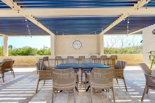 a dining room with a blue table and chairs at Seaside Serenity in Telchac Puerto