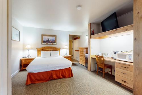 a bedroom with a bed and a desk with a microwave at Seventh Mountain Resort Unit 1914 in Bend