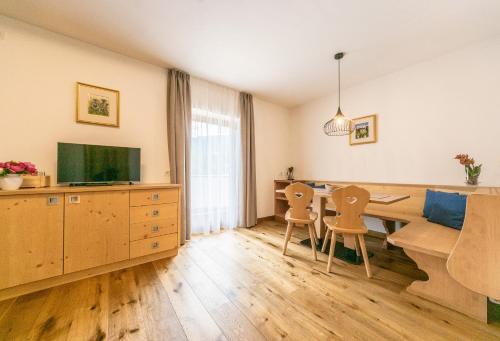 a living room with a dining table and a television at Agriturismo Corjel in San Vigilio Di Marebbe