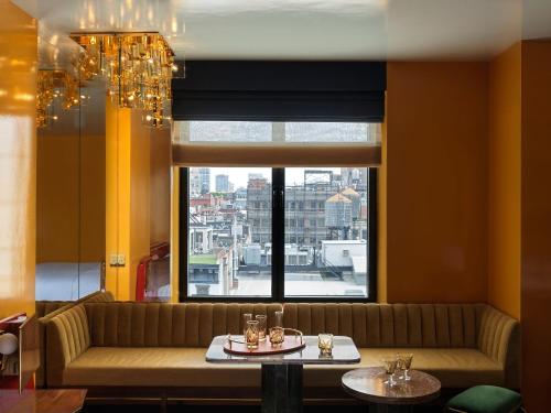 a living room with a couch and a large window at The Manner, The Unbound Collection by Hyatt in New York