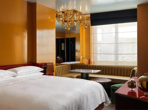 a hotel room with a bed and a chandelier at The Manner, The Unbound Collection by Hyatt in New York