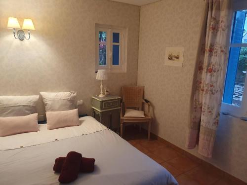 una camera da letto con un letto, una sedia e una finestra di Le Clos du Moulin Dijon,sa piscine, son jardin, au calme, la campagne à la ville a Digione