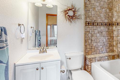 a bathroom with a sink and a toilet and a mirror at Storm's End in Waves