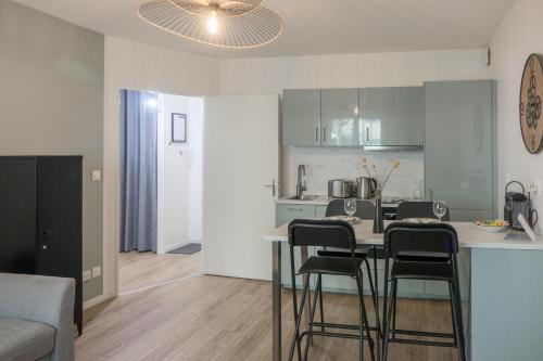 une cuisine avec une table et des chaises dans une pièce dans l'établissement Orléans - Appartement T2 avec parking privé - Douce Harmonie, à Orléans