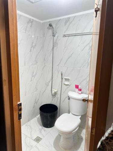 a white bathroom with a toilet and a shower at Affordable Condo in Cebu in Cebu City