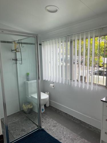 a bathroom with a glass shower and a toilet at CozyHomes Woolloongabba B&B in Brisbane