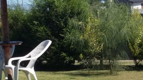 a white chair sitting in the grass next to a tree at Melodias Posada Boutique in Los Reartes