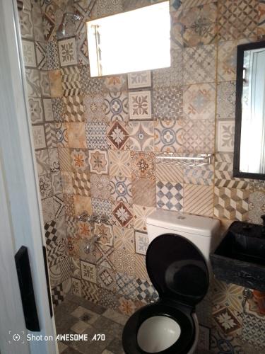 a bathroom with a toilet and a tiled wall at Lo de tina in Florencio Varela