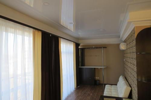 Boyard Inn في فلاديفوستوك: غرفة معيشة مع أريكة بيضاء ونافذة