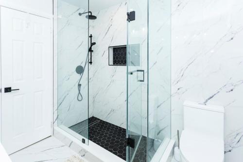 a shower with a glass door in a bathroom at Cozy 3BR Home with Parking, Backyard and Near Transit in Toronto