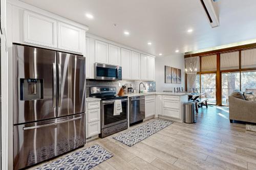 a kitchen with a stainless steel refrigerator and white cabinets at Tamarron 765 in Durango