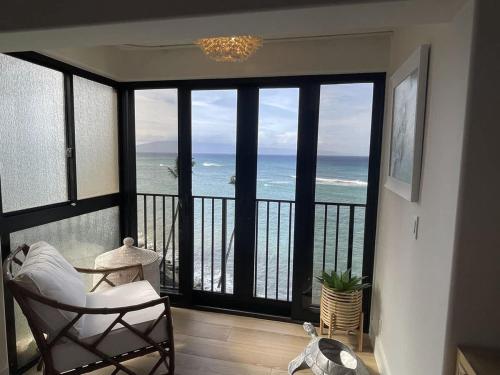 a room with a balcony with a view of the ocean at Unforgettable Oceanfront Stay , Nature, Luxury & Tranquility in Kahana