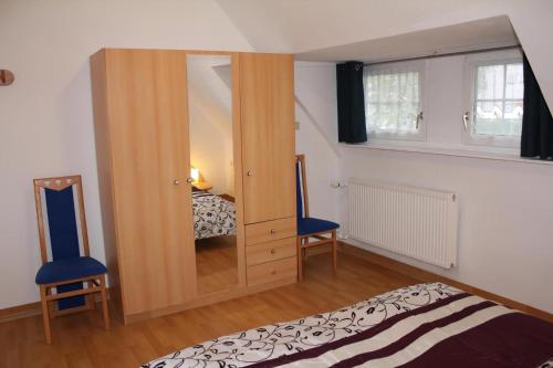 a bedroom with a wooden cabinet and a bed at Schöne Ferienwohnung In Daun Mit Garten in Daun