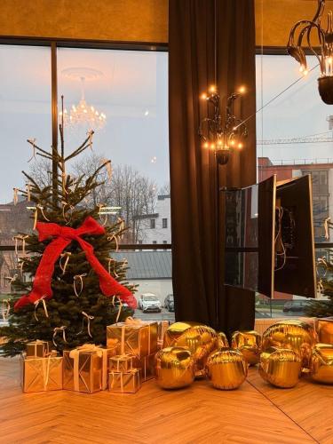 a christmas tree in front of a room with a table at ALL - Amberstone Lux Loft in Klaipėda