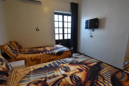 a room with two beds with a painting on them at Luxor Sapphire in Luxor