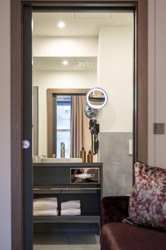 a mirror in a room with a couch and a sink at HOTEL andrä in Salzburg