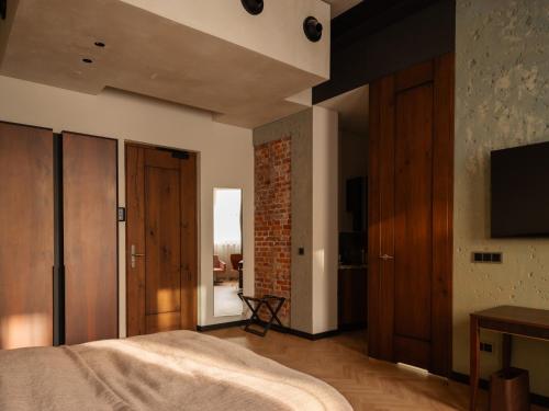 a bedroom with a bed and a tv on a wall at Grand Hotel in Łódź