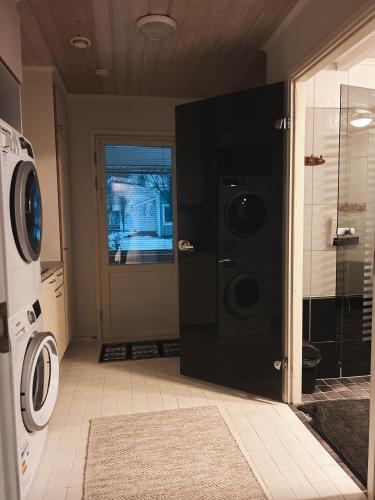 a laundry room with a washer and dryer next to a door at Winter Wonderland Home in Rovaniemi