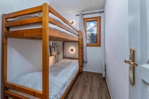 - deux lits superposés dans une petite chambre dans l'établissement Résidence Le Balcon Des Airelles - Appartement calme au cœur des Orres 1800 MAE-4074, aux Orres
