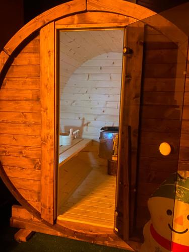 una puerta abierta a un baño en una casa de madera en Casa Maia, en Buşteni