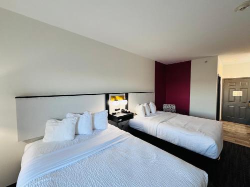 a hotel room with two beds with white pillows at Ramada by Wyndham Sparta/At Speedway in Sparta