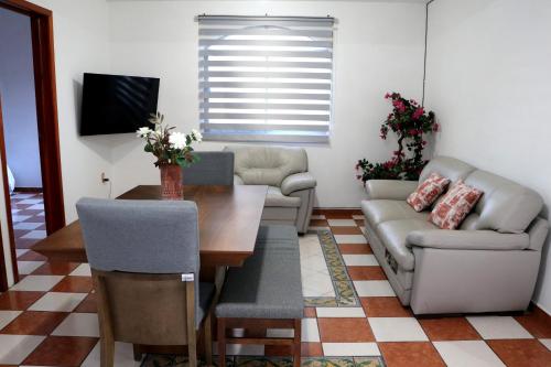 a living room with a couch and a table at Departamento Bugambilia in Oaxaca City