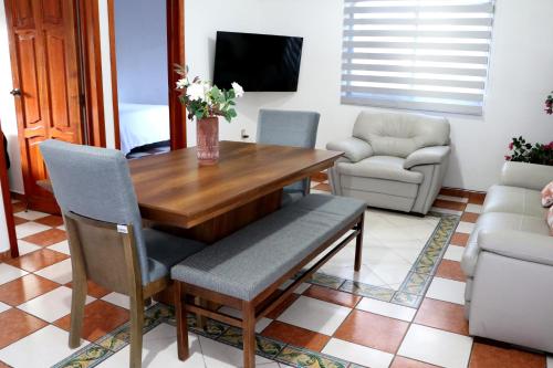 a dining room with a wooden table and chairs at Departamento Bugambilia in Oaxaca City